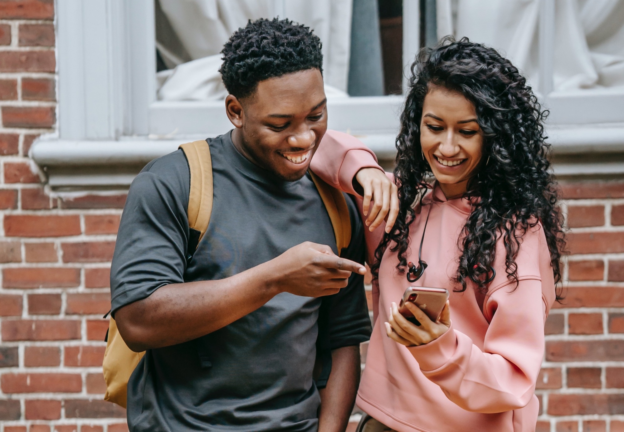 A young woman and a young man reading a text message on the woman's phone